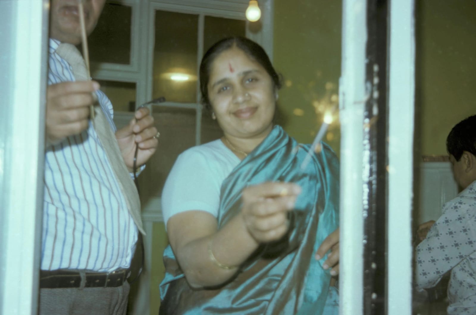 Sunil's mother holding a sparkler on Diwali night in England