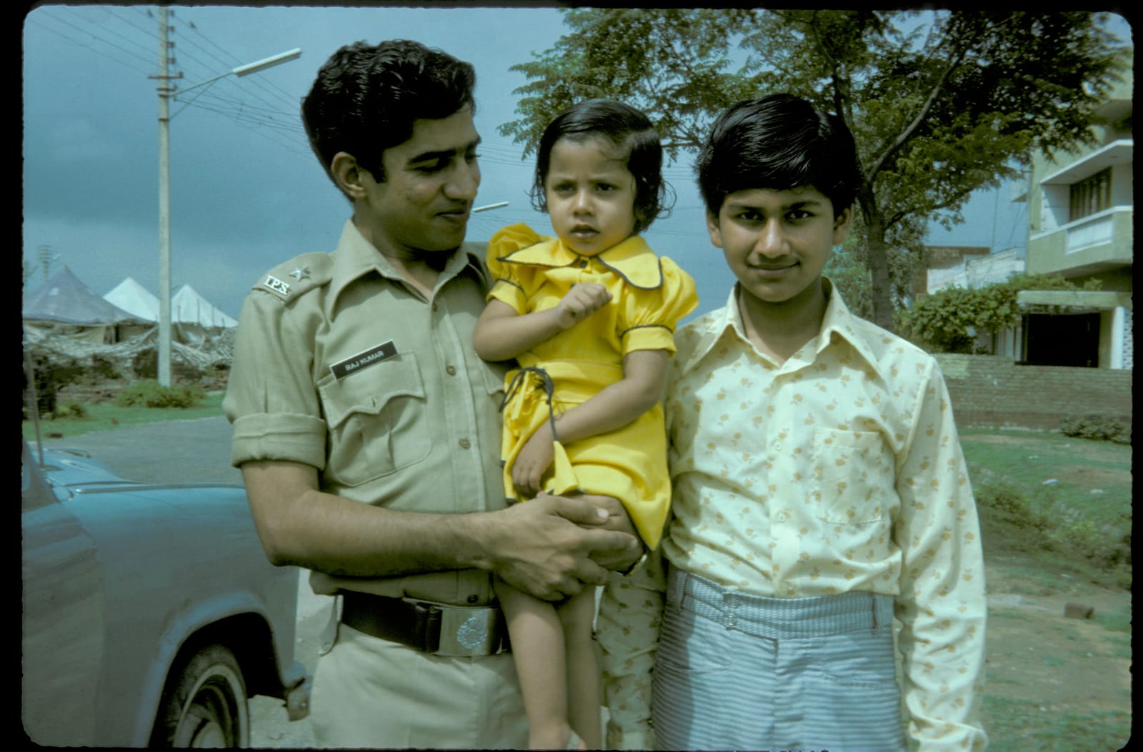 Raj Kumar in uniform holding a small child, with a young Sunil beside him